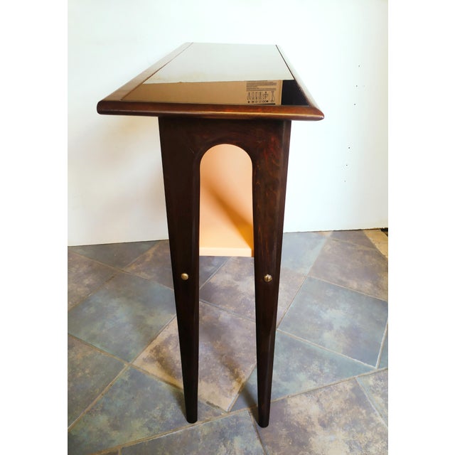 This wood vintage console is in the Ico Parisi style for form and design. Top glass in black color. Bottom shelf covered...