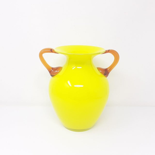 This vase is stunning with its very bright yellow color and classically balanced form. The glass handles are amber in...