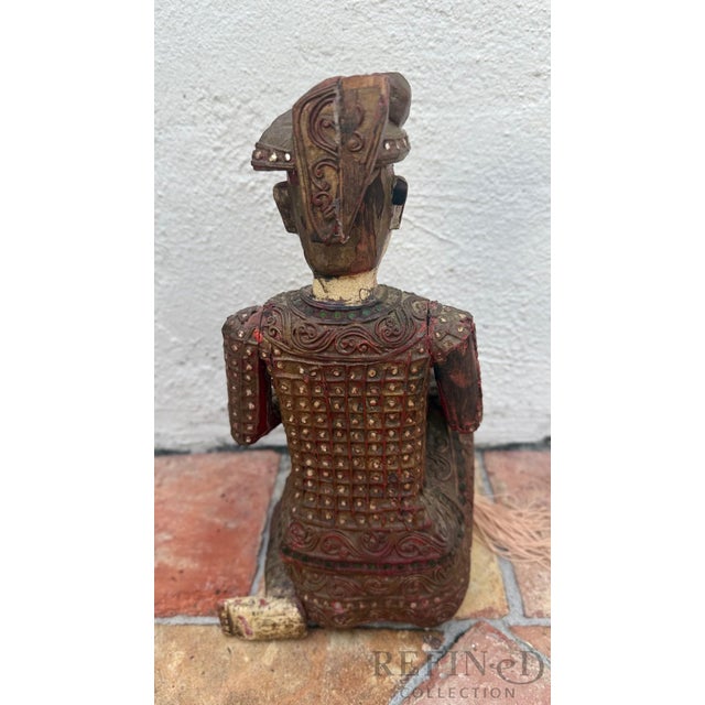 Polychrome Wood with Gilt Accents | 20th Century This expressive hand-carved Chinese figural sculpture depicts a seated...