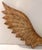 A large carved wood angel figure, depicted standing in flowing draped robes with one arm raised to play a horn or trumpet,...