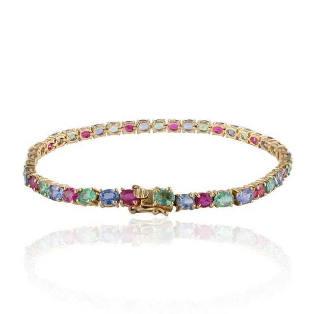 This is part of Chairish’s Fine Jewelry assortment. Exquisite Emerald, Ruby and Sapphire Tennis Bracelet in 14K gold...