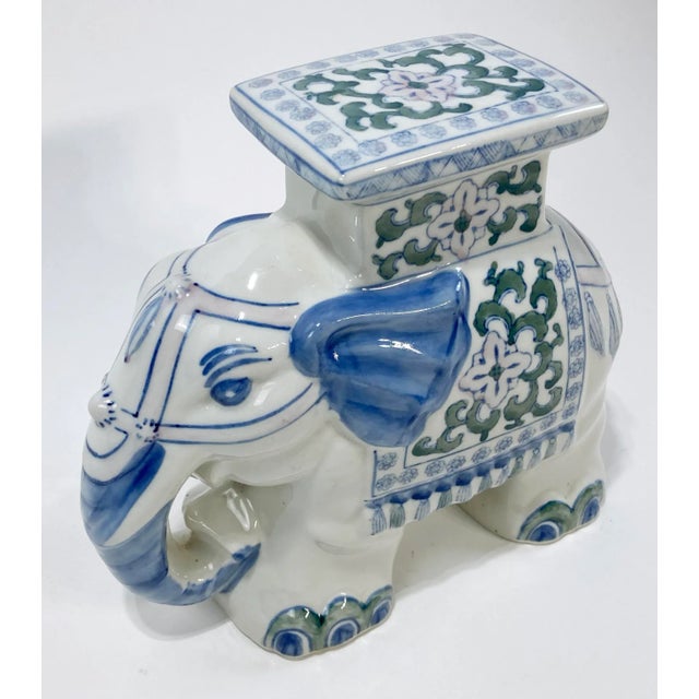 Charming vintage ceramic elephant plant stand featuring hand-painted floral pattern of blue and white with pinks and...