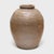 Coated inside and out with an olive green glaze, this large ceramic jar from early 20th century Thailand was originally...