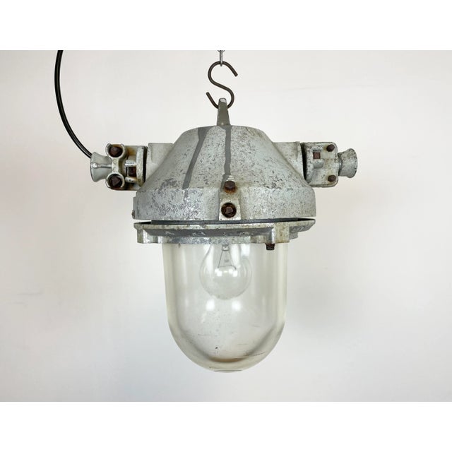 Grey industrial light with massive protective glass bulb. Made in former Czechoslovakia by Elektrosvit during the 1970s....