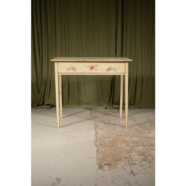 A charming Victorian pine side table, with a single frieze drawer, decorated in off white paint with line, rose and leaf...