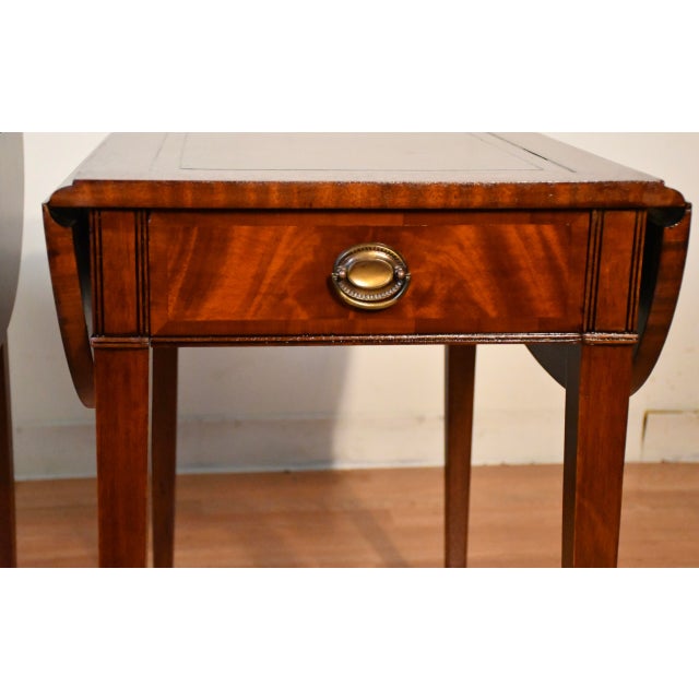We are pleased to offer this beautiful pair of Regency Pembroke drop-leaf side tables, by Weiman Furniture from the 1930s....
