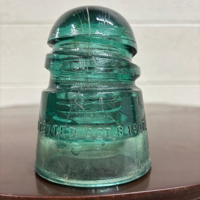 This is a gorgeous antique teal glass Hemingray insulator embossed “HEMINGRAY – Patented Oct 8, 1907.” Produced by the...