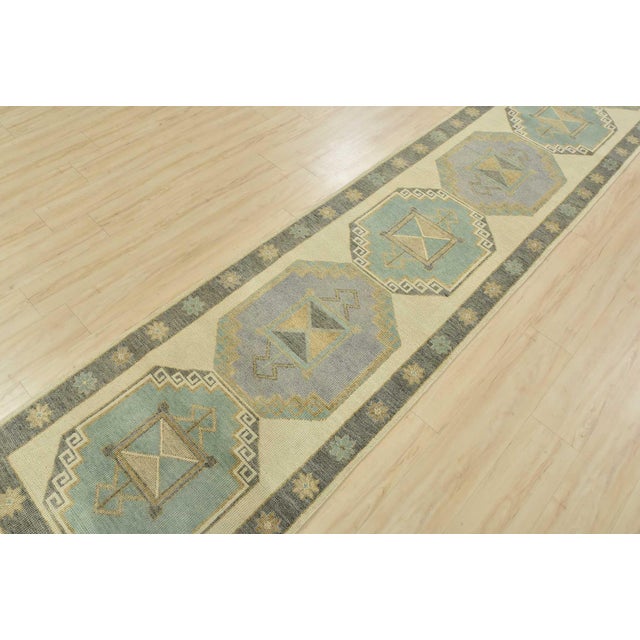 This tribal geometric Anatolia runner is hand-knotted with an all-wool pile on a cotton foundation. This rug is new and in...