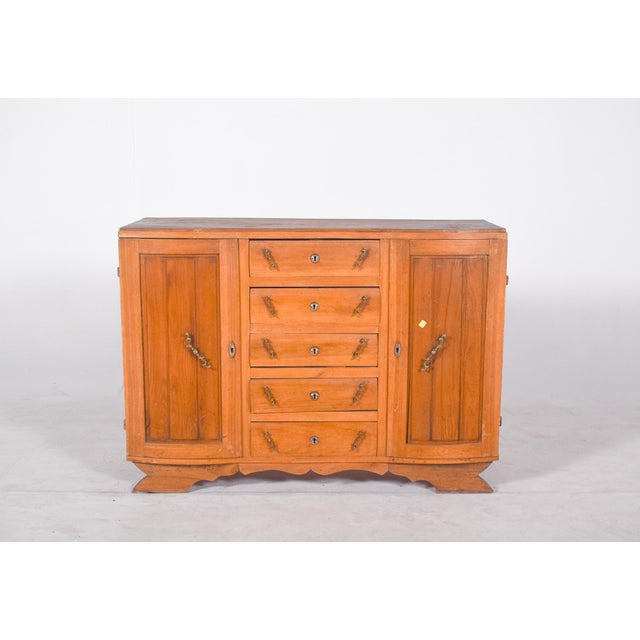 Sideboard with five drawers and two doors. Wood with a light finish and robust structure, comprising five central drawers...