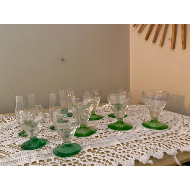 A charming collection of ten vintage uranium glass aperitif glasses, featuring delicate clear glass bowls and striking...