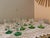 A charming collection of ten vintage uranium glass aperitif glasses, featuring delicate clear glass bowls and striking...