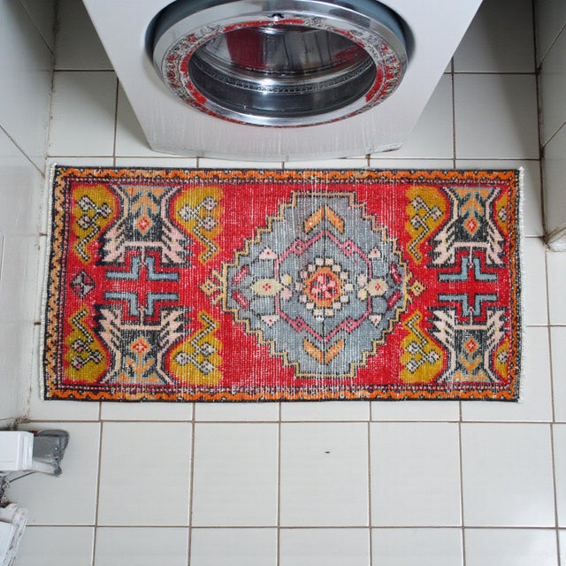 This vibrant hand-knotted Nigde rug from Central Anatolia serves as a captivating vintage accent for smaller spaces. Its...