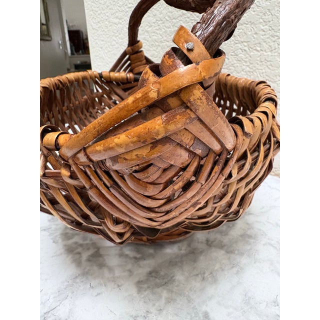 Vintage rustic Asian style wood woven basket with arched natural tree branch handle. Perfect for decor or rolled hand...