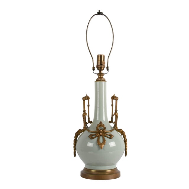 This Bronze Mounted Celadon Porcelain Table Lamp presents a refined balance of sculptural form and decorative detail. The...