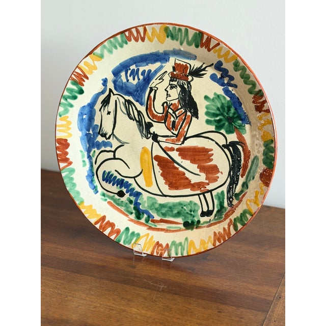 A striking and highly decorative mid-century glazed earthenware charger, likely French or Italian, dating to circa...