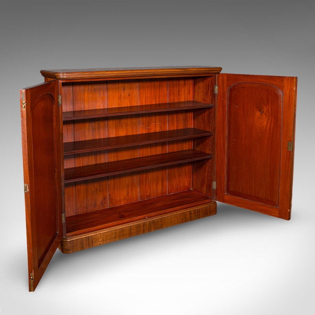 This is a large antique captain's bookcase. An English, mahogany enclosed book cabinet, dating to the late Victorian...