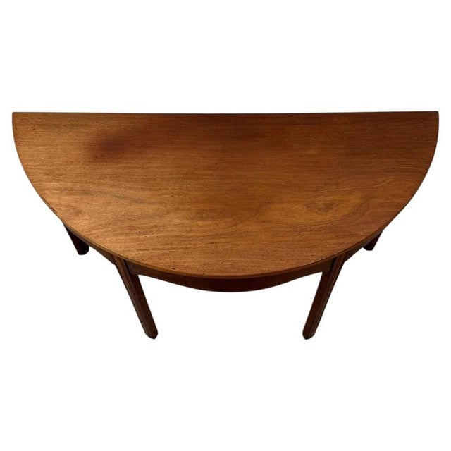 An elegant 18th century English Georgian demi-lune side table, finely constructed in mahogany and distinguished by its...
