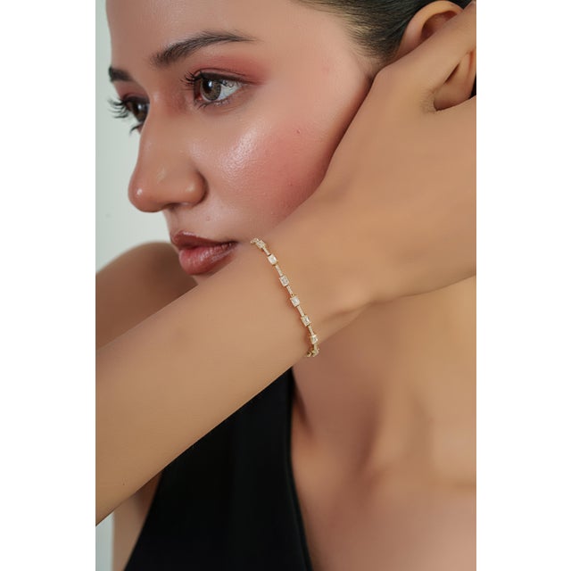 This tennis bracelet features 3.6 carats of emerald-cut diamonds set in 14K yellow gold. Emerald cut diamonds accented by...
