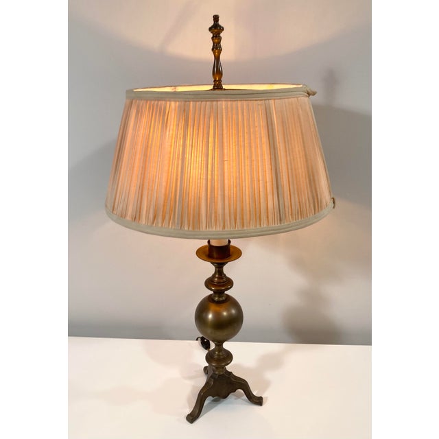 Bring substance to your dark academia study with this solid, brass cannonball form and tripod base lamp. The brass has a...