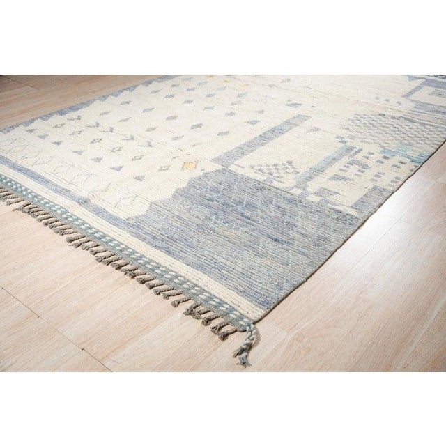 This hand knotted pile rug features a primary color palette of ivory, beige, cream, and white. Constructed from wool, this...