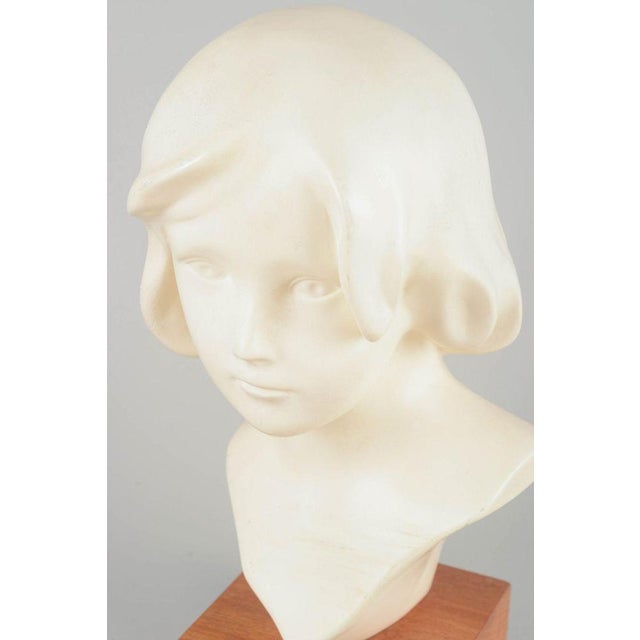 Påskliljan. Bust sculpture, mid-20th century. White-patinated plaster bust of a young girl on solid wooden base with...