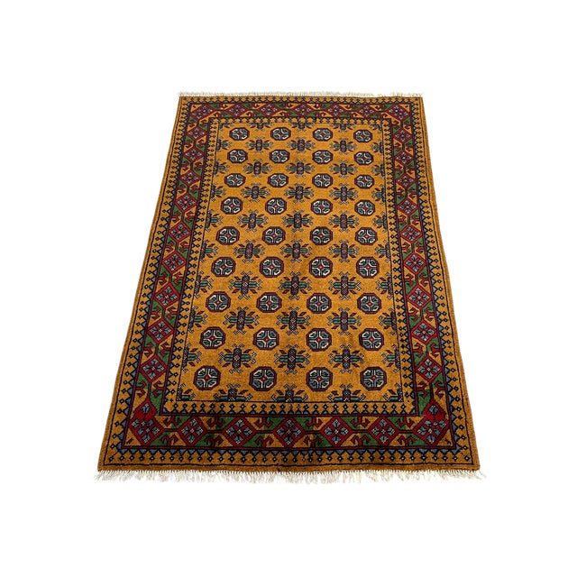 An allover pattern of repeating octagonal gul motifs gives this tribal area rug its distinctive rhythm. The golden-ochre...