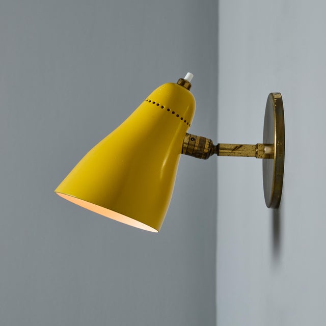 Pair of 1950s Giuseppe Ostuni Model #101 Yellow Articulating Sconces for O-Luce. Executed in patinated brass and yellow...
