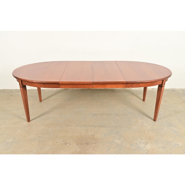An exceptional French Regency Louis XVI style extension dining table In the manner of Baker Furniture USA, Circa Late 20th...
