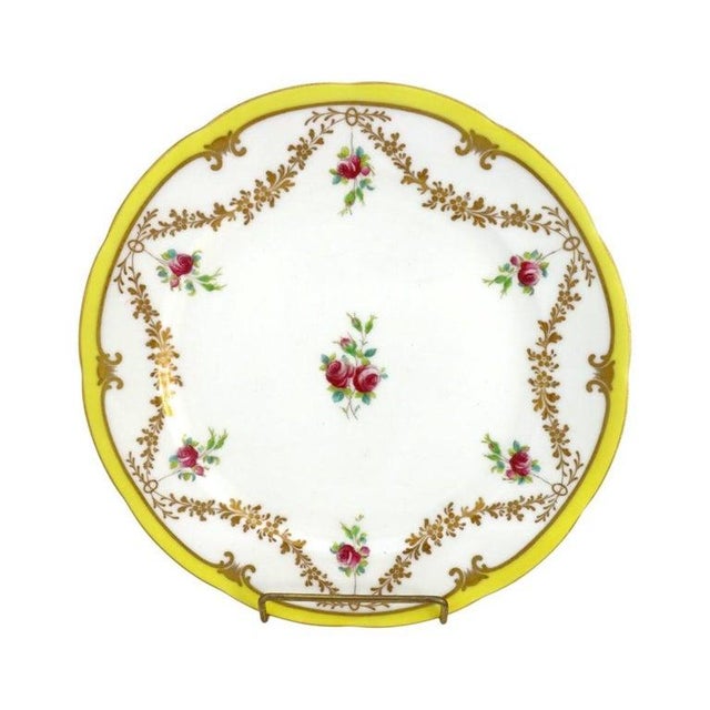 This exquisite set presents fourteen antique English Cauldon Ware porcelain dinner plates, dating to approximately 1920....