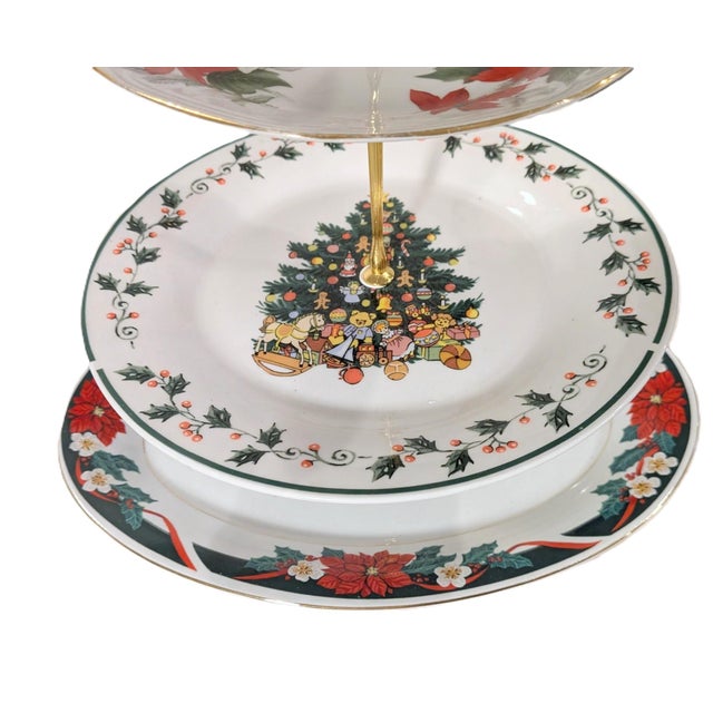 A festive four-tier serving stand assembled from complementary Christmas china patterns by Tienshan, Gibson Designs, and...