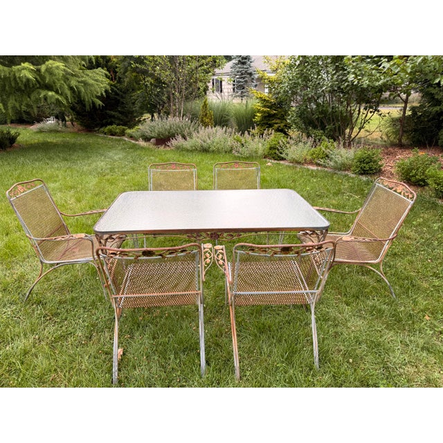 A classic vintage Woodard style wrought iron dining set in the beloved “ Rose” design Comprising a rectangular glass-top...