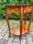 This refined French side table dates to approximately 1970 and reflects the elegant symmetry and restrained ornamentation...