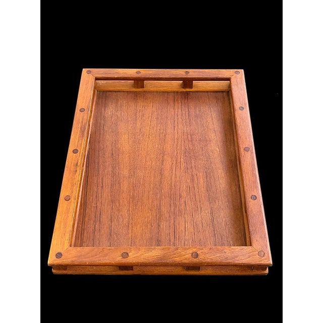 Resembling a ship's galley rail, this is a classic Teak wood "Captain's" (and also referred to as a Butler's) tray...