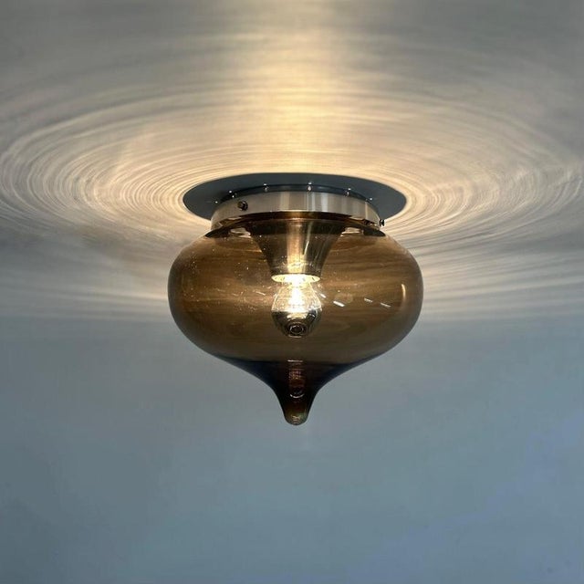 Dijkstra ‘Drop’ ceiling lamp from the 1970s; brown smoked glass in the shape of a drop with an aluminum base. This lamp...
