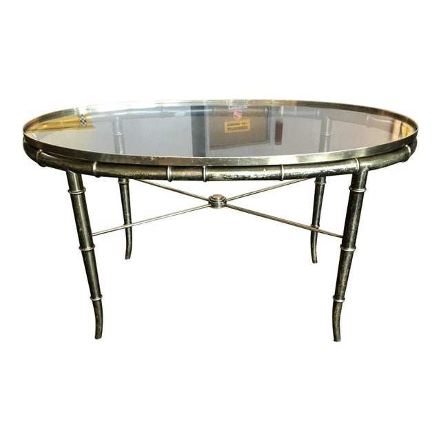Asian influenced faux bamboo brass base coffee table with original glass in-set top, executed by legendary cabinetmaker of...