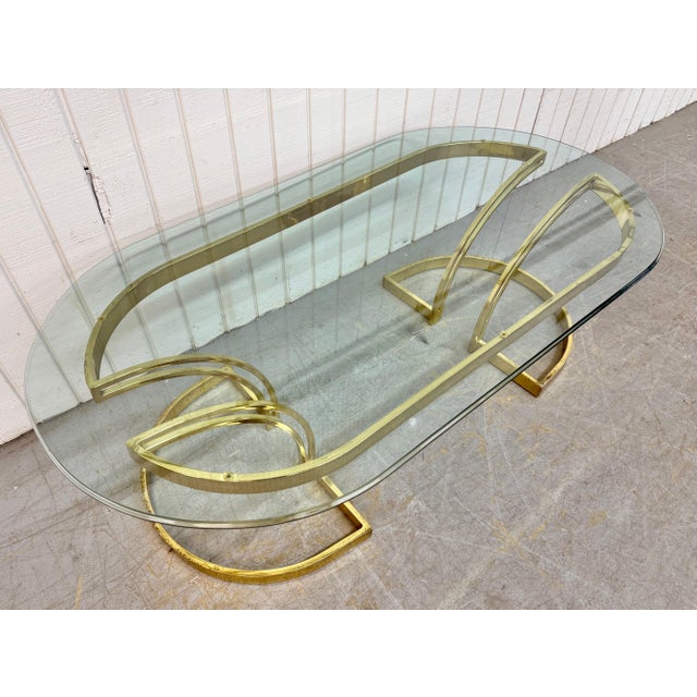 This listing is for a Vintage Brass & Oval Glass Top Coffee Table. Featuring a post-modern design in the style of Milo...