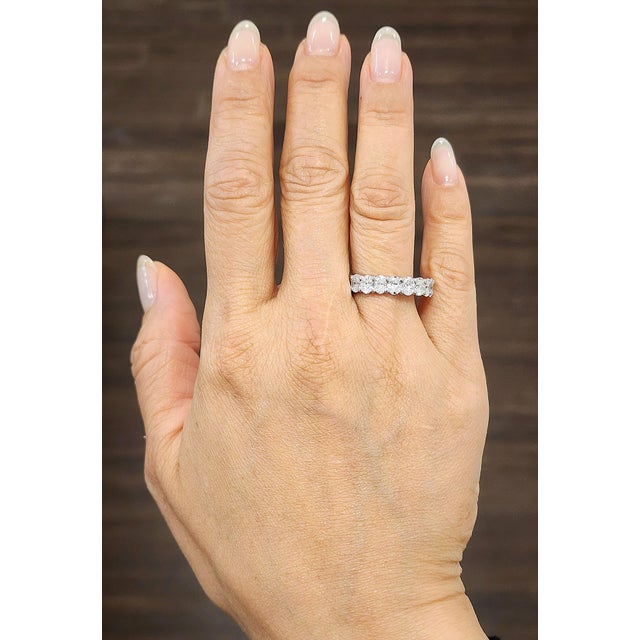 Enhance your collection with this exquisite 4.69 ct diamond band ring. Featuring 20 oval-cut, natural white diamonds of...