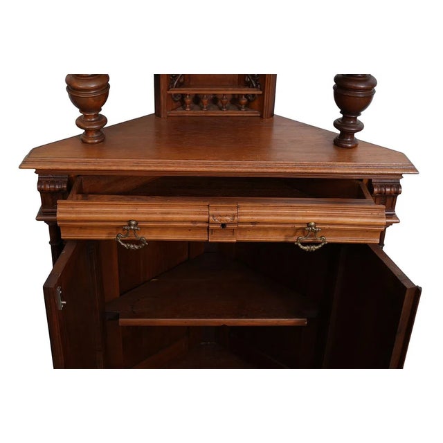 This antique French walnut corner cupboard, made circa 1880, features a rare raised panel door style with intricate...