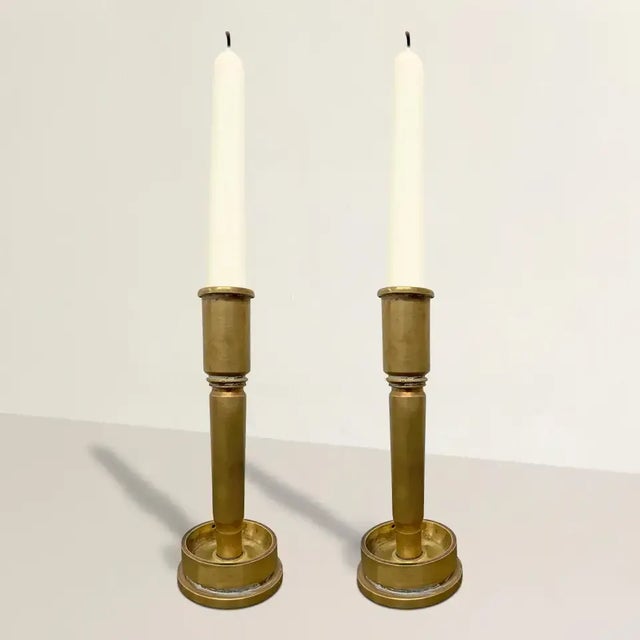 A wonderful and thought provoking pair of mid 20th century American Folk Art candlesticks made from reused brass.