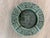 A vintage crushed malachite Aztec-style round ashtray with a glass center. Features a Quetzalcoatl or Mayan God motif in...