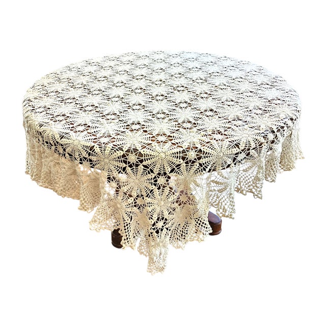 A finely hand-crocheted lace textile showcasing intricate rosette motifs arranged in a geometric web pattern. Crafted from...