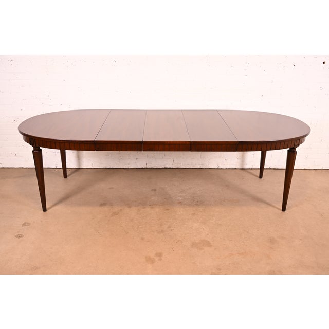 A beautiful French Regency Louis XVI style mahogany extension dining table By Henredon USA, Circa 1960s Measures: 60"W x...