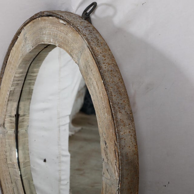 Originally a wagon wheel with an iron rim, the spokes have been removed and a mirror added to make a sophisticated rustic...