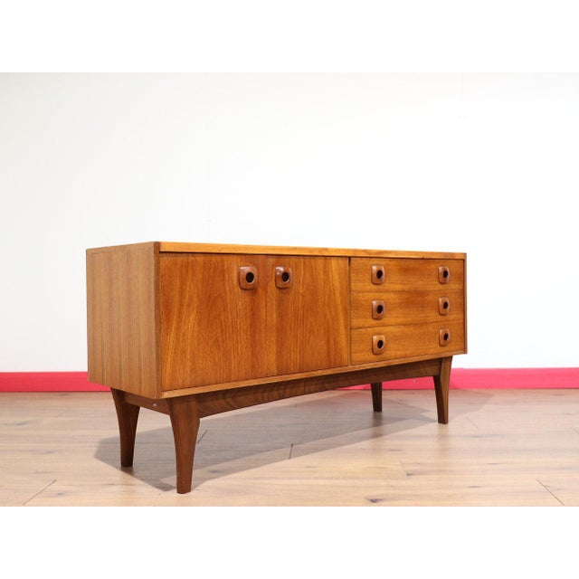 A beautiful teak short sideboard that embodies the timeless elegance of Danish style, this vintage credenza from Mid...