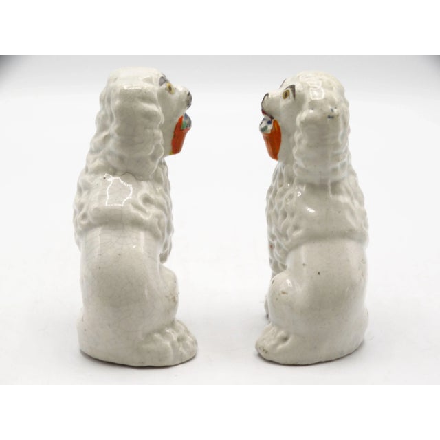19th-Century English Staffordshire spaniel dogs each with a basket in his mouth. They are hand molded and hand painted...