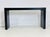 Architectural in form and understated in its elegance, this modern console table features a rich black cerused oak finish...