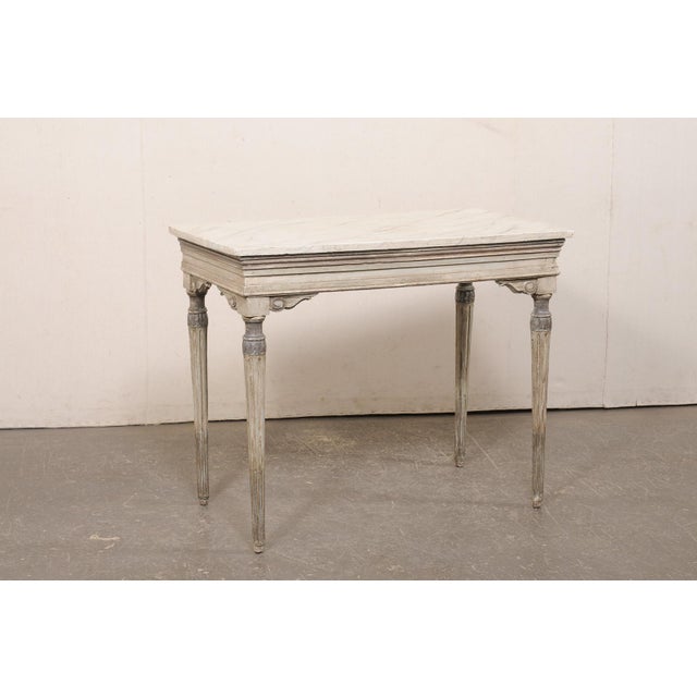 A French Neoclassical period carved and painted wood console table from the 18th century. This antique table from France...