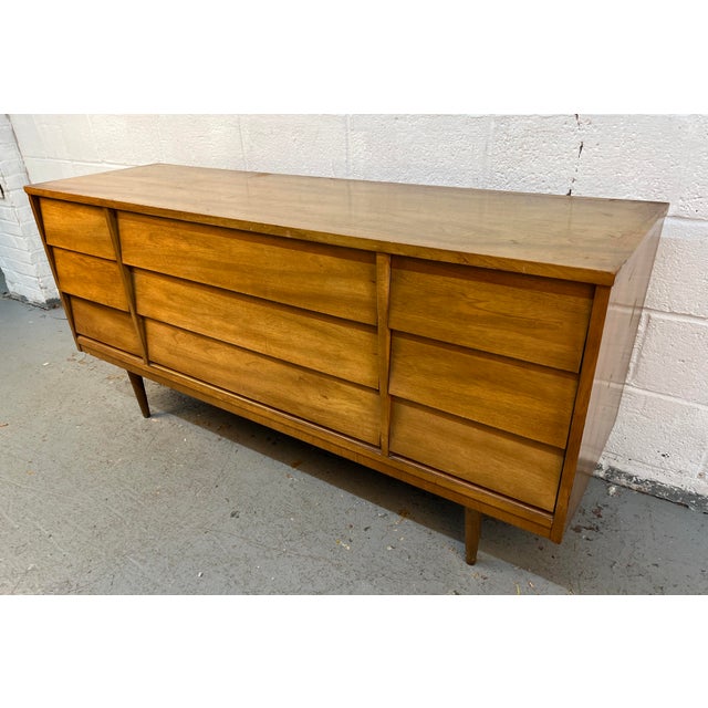 Bring timeless mid-century style and exceptional craftsmanship into your home with this vintage nine-drawer dresser by...