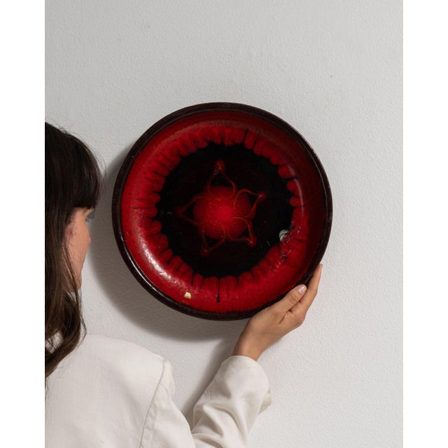 This 1960s plate from Germany is finished in red, worked in pottery. Its form follows honest, well-proportioned lines...
