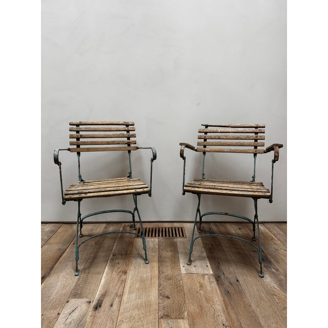 A rustic pair of French bistro chairs. Painted metal frames with original slatted wood. Very charming.Very distressed....